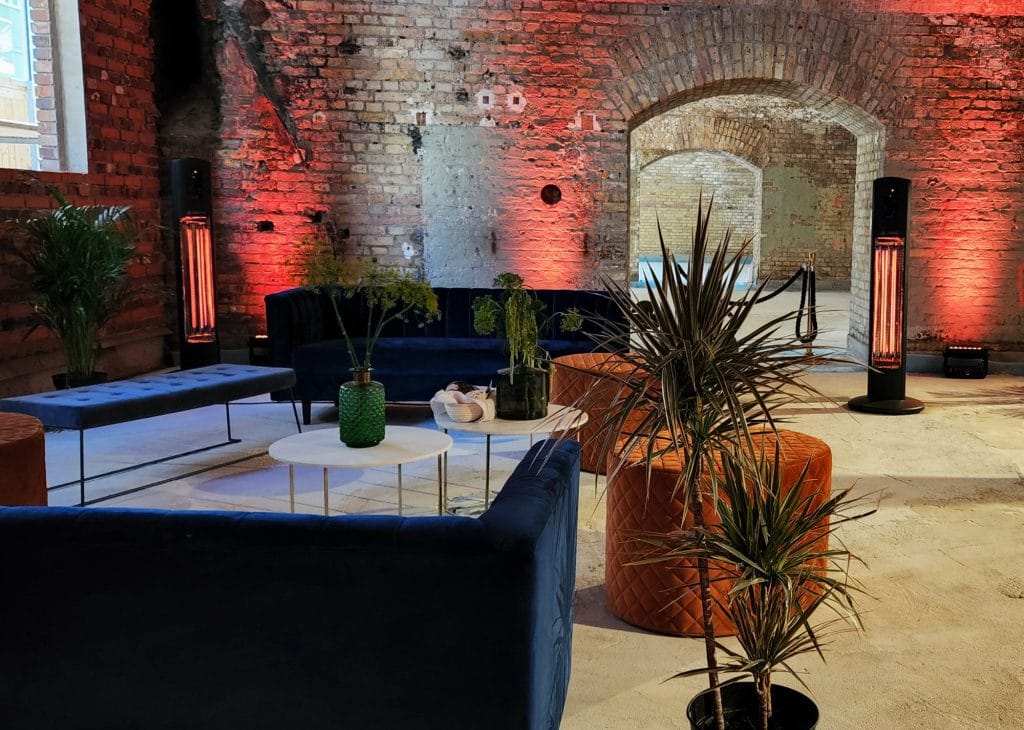 Stilvolle Lounge mit Pflanzen, gemauerten Wänden und modernen Möbeln in industriellem Ambiente.