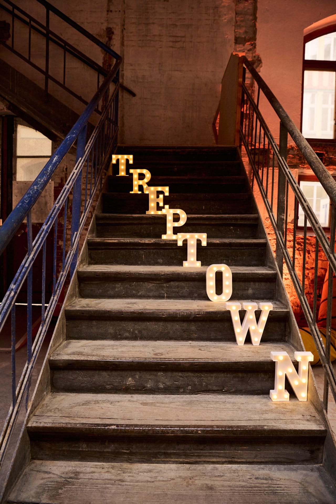 Alte Gebäudetreppe mit leuchtenden Buchstaben Treptown auf den Stufen.