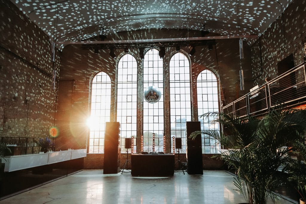 Große Eventhalle mit Diskokugel, Sonneneinstrahlung und moderner Einrichtung für Feierlichkeiten.