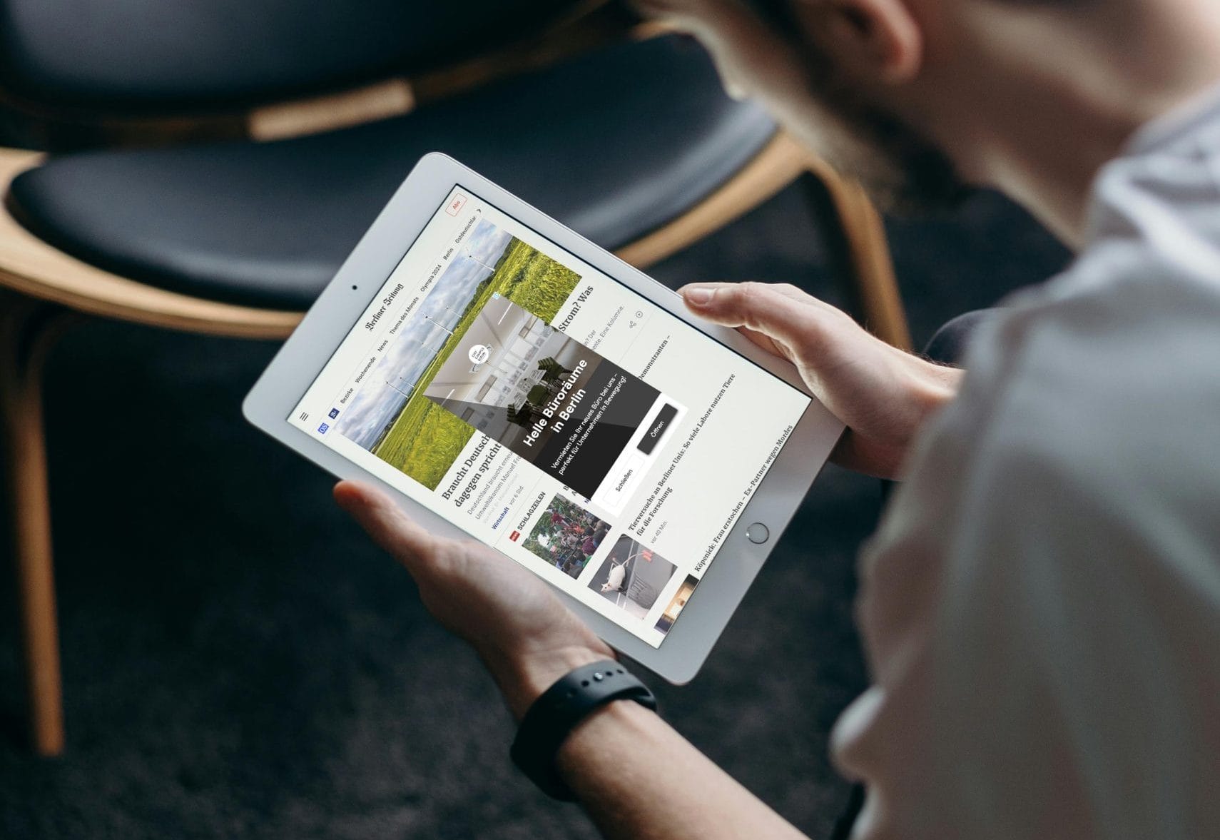 Nutzer liest Nachrichten auf einem iPad-Tablet, fokussiert auf Berlin-Büroräume-Anzeige.