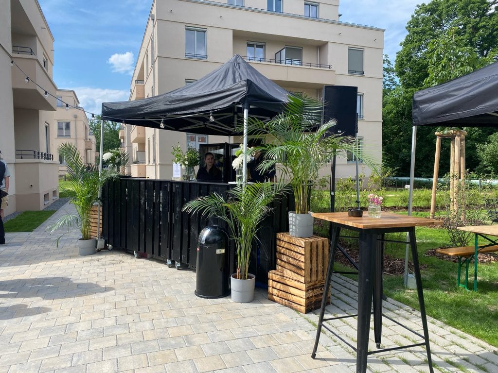 Außenbereich mit Pavillons, Pflanzen und stehendem Tisch in modernem Wohngebäude-Hofgarten.