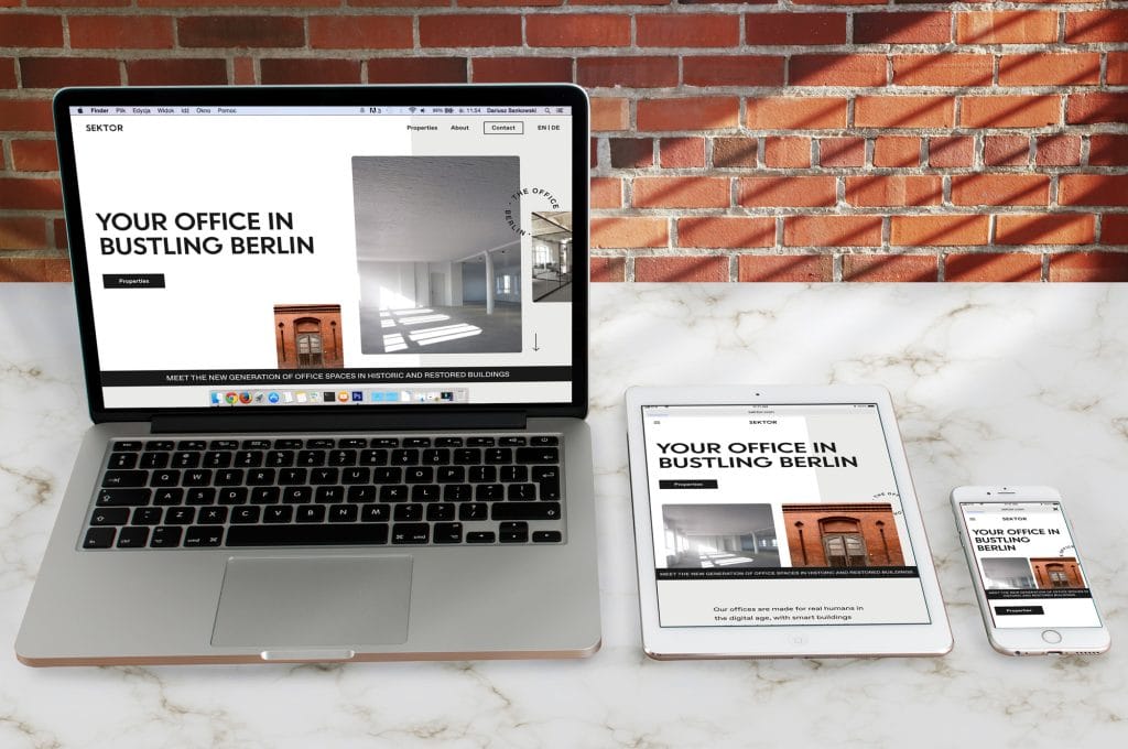 Laptop, Tablet und Smartphone zeigen Website über Büroflächen in Berlin vor Backsteinwand.