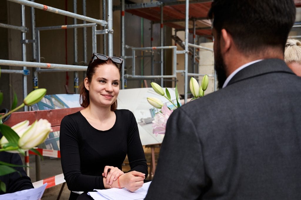 a woman sitting at a table with a man in a suit