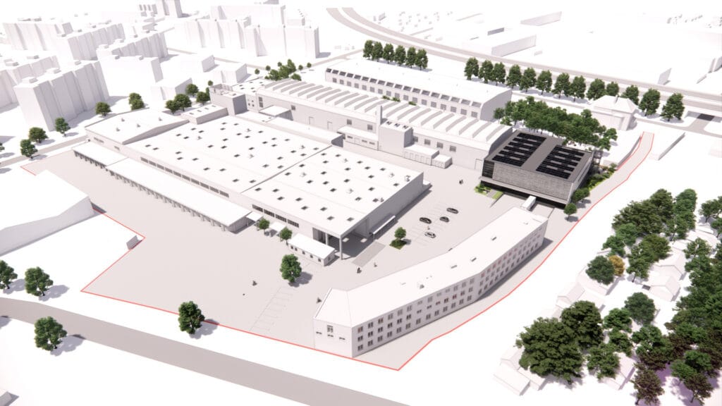 Vogelperspektive auf modernes Industriegebiet mit Gebäuden, Parkplätzen und Bäumen im städtischen Umfeld.